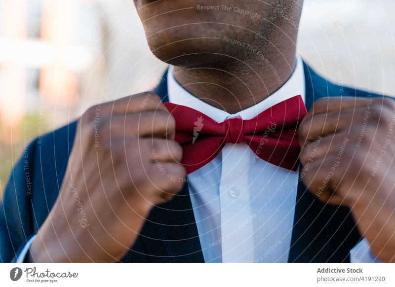 Crop groom adjusting bow tie man style red wedding newlywed suit fancy male ethnic black african american elegant marriage celebrate tuxedo ceremony garment