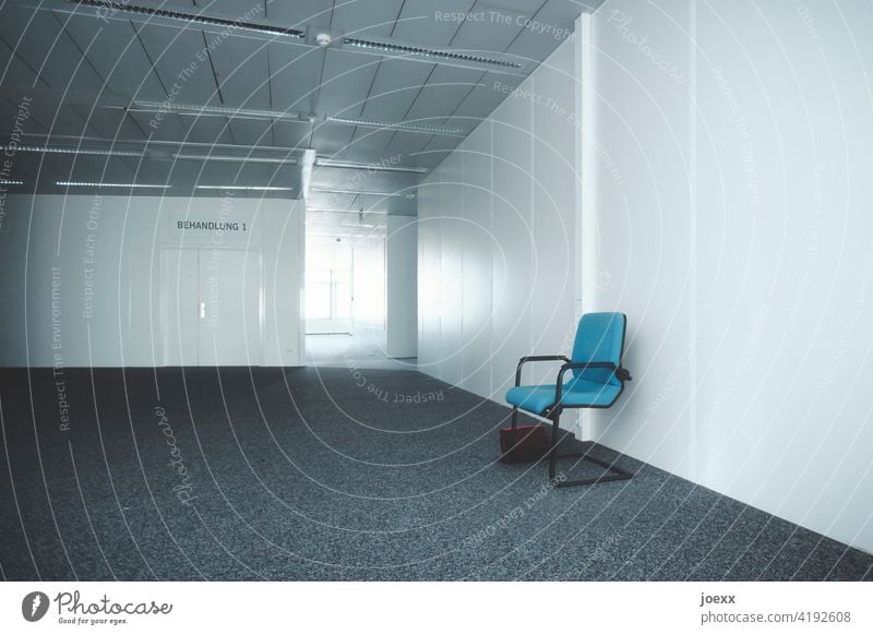 Cold anonymous waiting room in front of treatment room with blue chair and forgotten handbag Wait Waiting room Waiting room for doctors Chair Blue Gray Forget