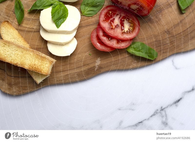 Homemade Italian caprese salad with sliced tomatoes, mozzarella cheese, basil and olive oil food mediterranean italian plate background fresh healthy olive il