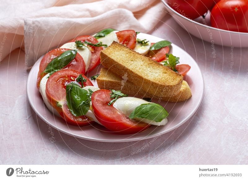 Homemade Italian caprese salad with sliced tomatoes, mozzarella cheese, basil and olive oil food mediterranean italian plate background fresh healthy olive il