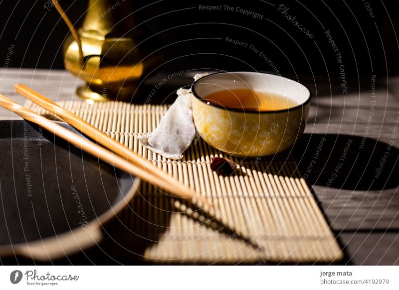Dark tea background with cup of hot tea on the table. Copy space for your design. Authentic vintage style. Traditional tea ceremony arrangement chinese tea
