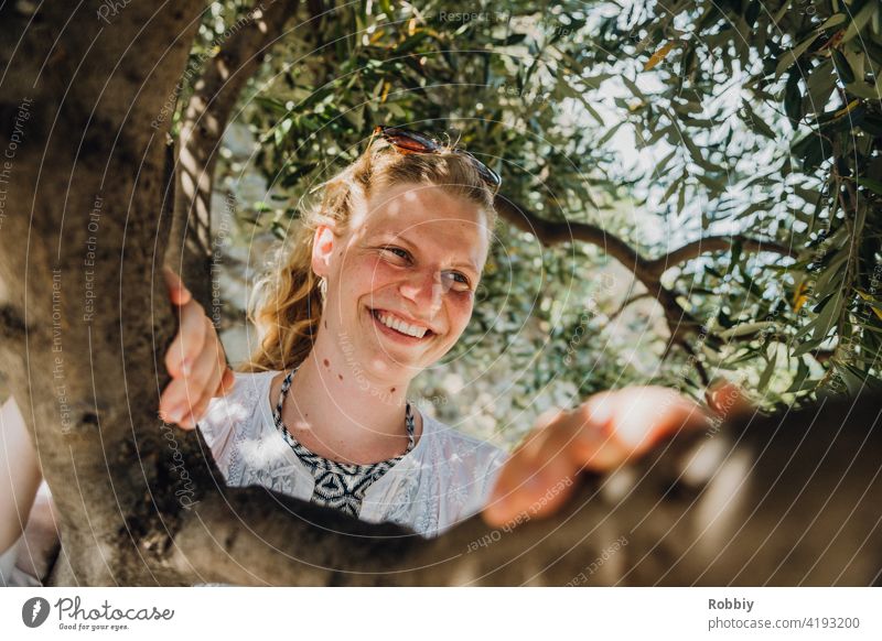 Smiling young woman under olive tree Olive tree Young woman Blonde Sun Sunlight Tree portrait pretty vacation Summer Summer Feeling Exterior shot Colour photo