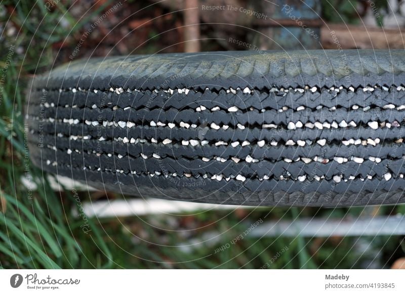 White pebbles in the grooves of an old tyre of a trailer for the tractor on a farm in Rudersau near Rottenbuch in the district of Weilheim-Schongau in Upper Bavaria