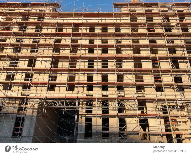 Modern apartment building with facade in beige with scaffolding in the sunshine in Offenbach am Main in Hesse New building housing Architecture