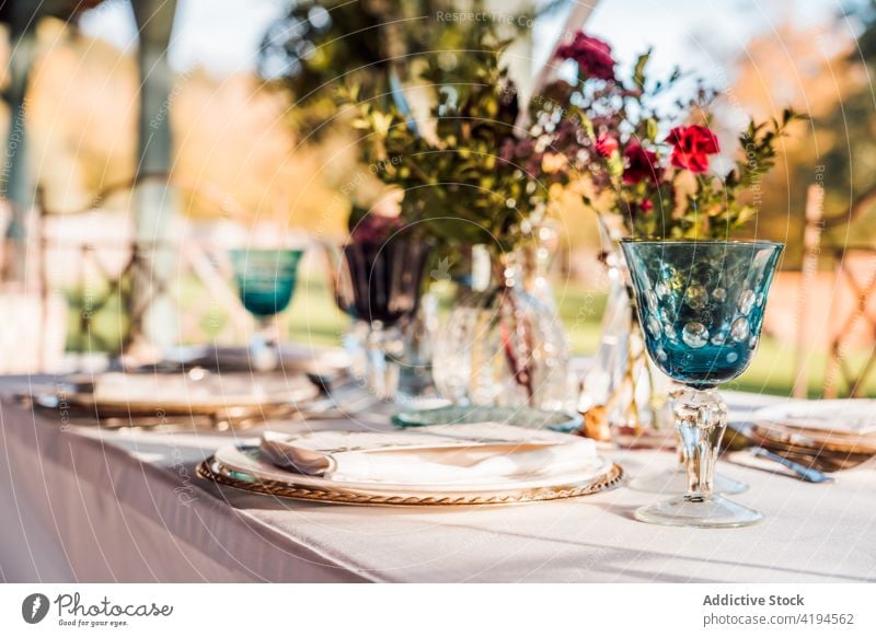 Banquet table with wineglasses near plate and cutlery bunch vase event flower reception celebrate festive banquet elegant decor bouquet natural transparent