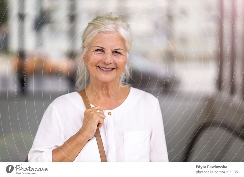 Portrait of senior woman smiling in the city people retired retirement leisure standing confident attractive urban street positive joy enjoyment cheerful happy