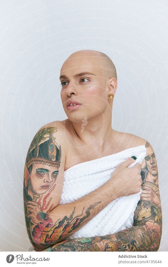 Feminine transgender man in towel on white background gay feminine tattoo lgbt gentle sensitive self regard tender dreamy portrait beauty natural accept