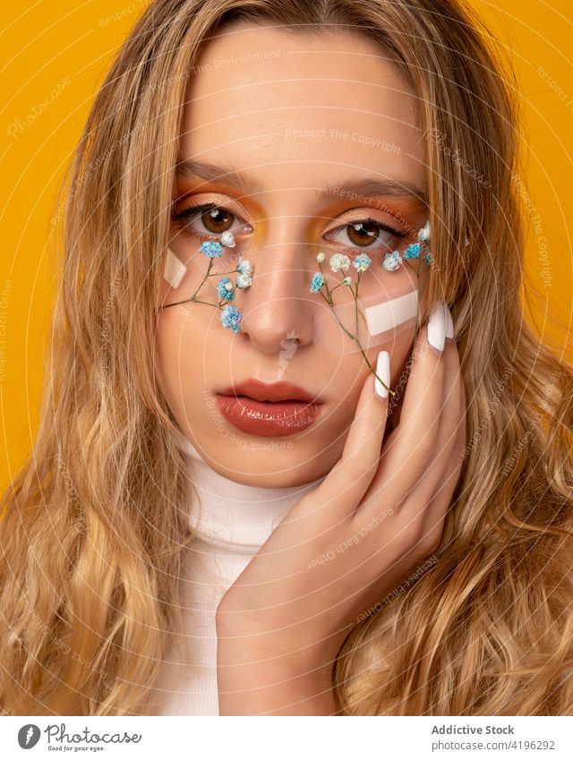 Crop sensitive woman with gypsophila flowers on face under plaster band touch face style unusual charming gorgeous concept makeup pretty perfect attractive