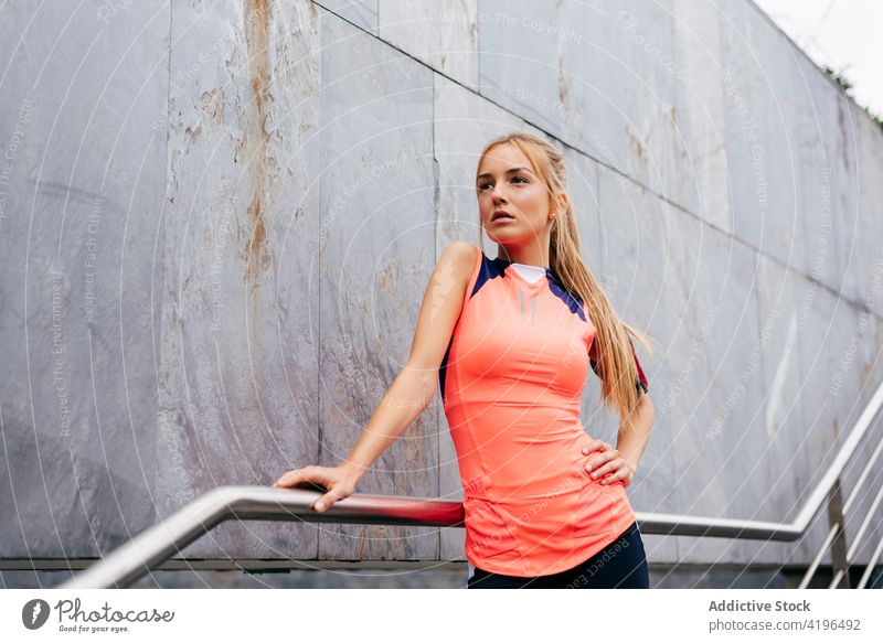 Attractive blonde sportswoman resting on stairs - a Royalty Free