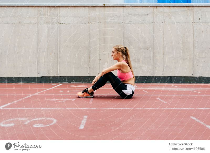 Blonde sportswoman resting on the track blonde city run running exercise lifestyle healthy attractive sportswear preparation athlete female caucasian fit