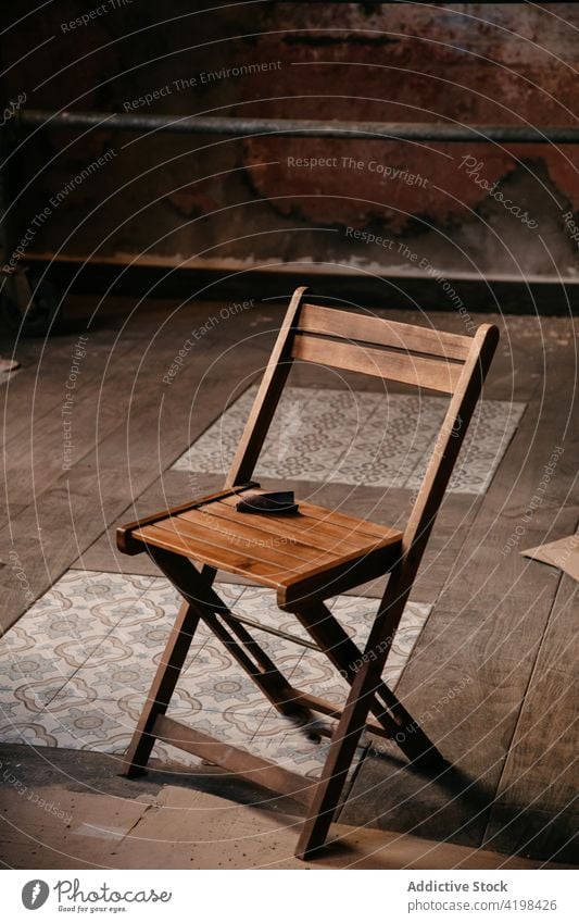 Wooden stool in middle of empty room during renovation process chair renovate repair dusty dirty renewal reconstruct property decay house mess spacious relocate