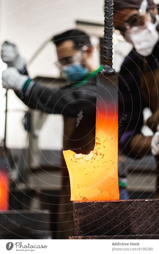 Blacksmiths forging hot metal with hammer in workshop men blacksmith hit detail metalwork forge industrial male tool occupation glove master artisan handwork