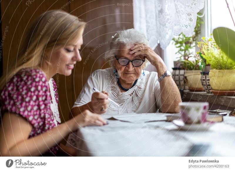 Young woman spending time with her elderly grandmother at home people senior mature casual female Caucasian house old aging domestic life pensioner grandparent