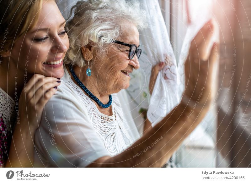 Young woman spending time with her elderly grandmother at home people senior mature casual female Caucasian house old aging domestic life pensioner grandparent