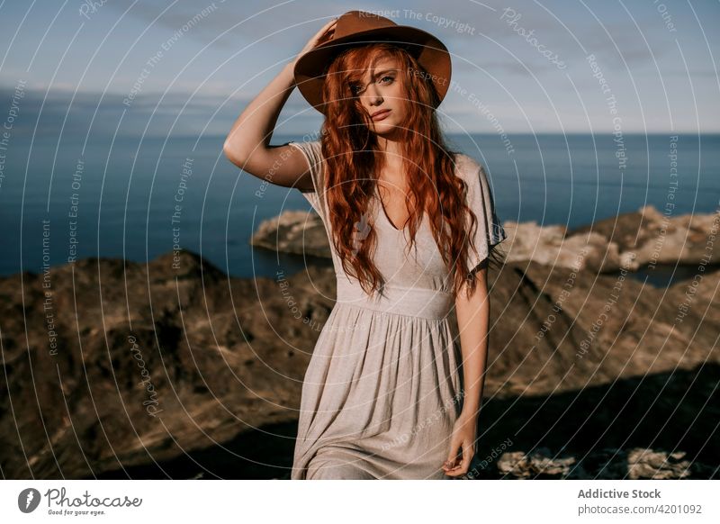 Redhead woman relaxing at mountain seaside red hair rock high top redhead nature coast ocean standing wilderness freedom travel natural landscape environment