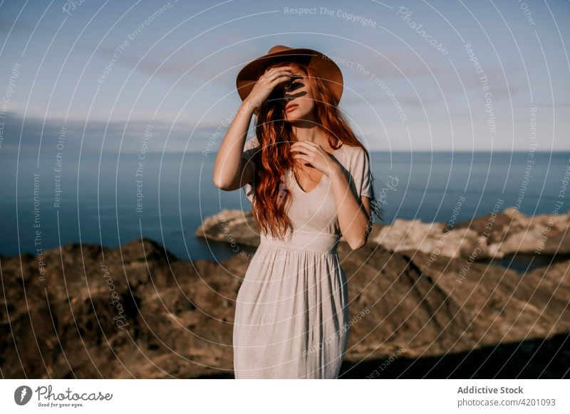 Redhead woman relaxing at mountain seaside red hair rock high top redhead nature coast ocean standing wilderness freedom travel natural landscape environment