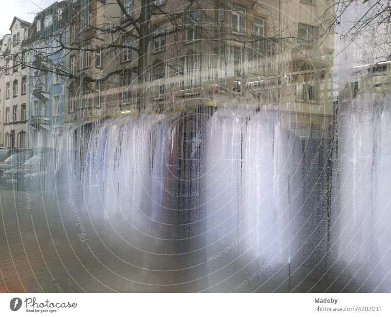 Reflection of a row of houses in the fogged window of a dry cleaner and laundry in the district of Bockenheim in Frankfurt am Main in the German state of Hesse