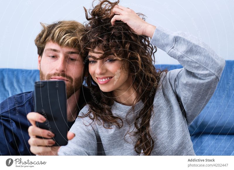 Happy couple taking selfie on smartphone happy together cheerful smile love self portrait mobile casual using moment hug embrace memory cellphone bonding date
