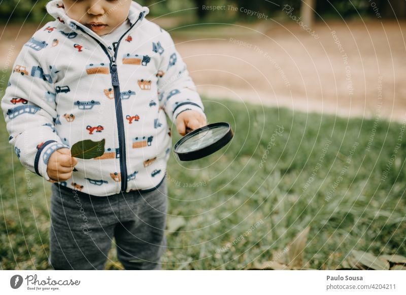 Child playing with magnifying glass 1 - 3 years Caucasian Magnifying glass explore Curiosity Happy Happiness Colour photo Nature Joy Infancy Lifestyle