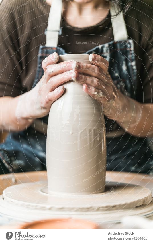 Anonymous craftswoman creating earthenware in workshop pottery creative clay wheel handmade female artisan tableware ceramic hobby skill handicraft master