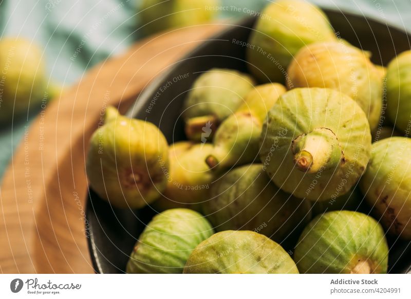 Fresh and ripe sweet green figs on the wood plate table fruit bowl organic food diet nature healthy juicy fresh raw freshness blue ingredient dessert closeup