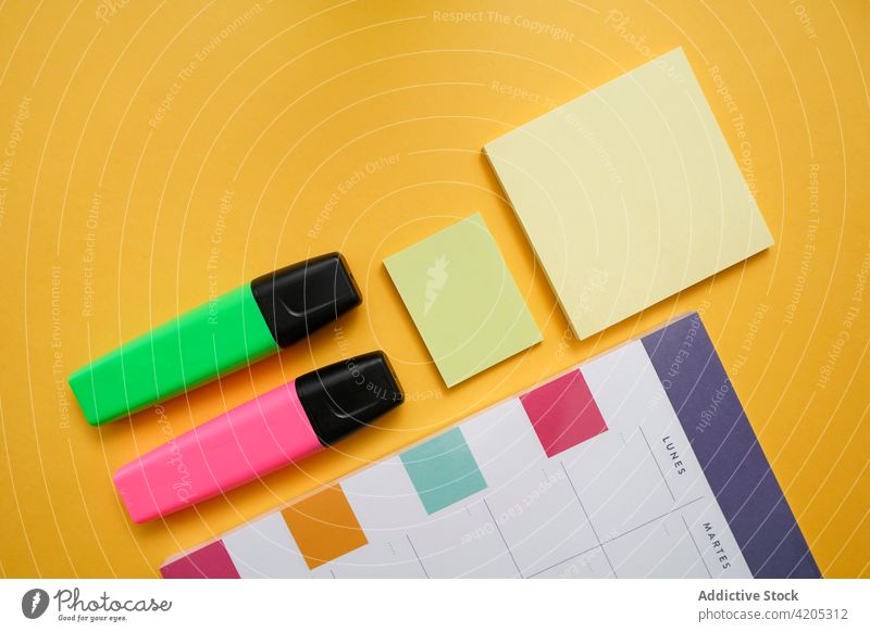 Colorful office supplies on yellow background calendar planner marker sticky note supply color set schedule organize colorful stationery reminder workplace
