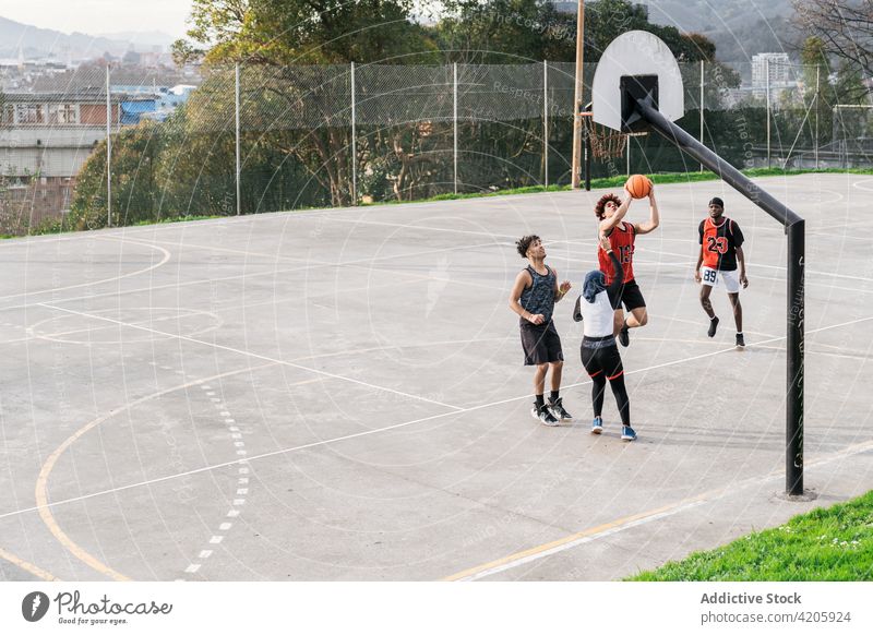 Diverse people playing basketball on court streetball player together game team sports ground multiracial multiethnic diverse black african american muslim