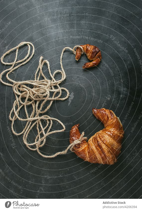 Croissant with rope on black background croissant baked bread bun food fresh bakery pastry breakfast shape craft cuisine nutrition crust rustic culinary