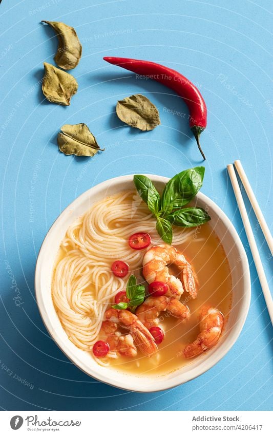 Tom yum soup in bowl with chopsticks on blue background thai leaves herb freshness thai food citrus noodles bowl tom yam kung asian cuisine lemongrass tomato