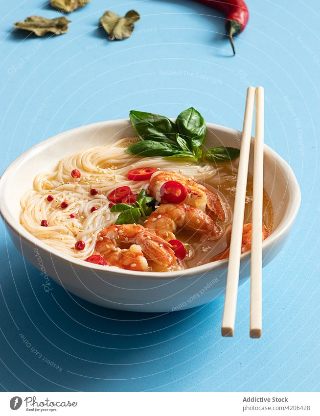 Tom yum soup in bowl with chopsticks on blue background thai leaves herb freshness thai food citrus noodles bowl tom yam kung asian cuisine lemongrass tomato