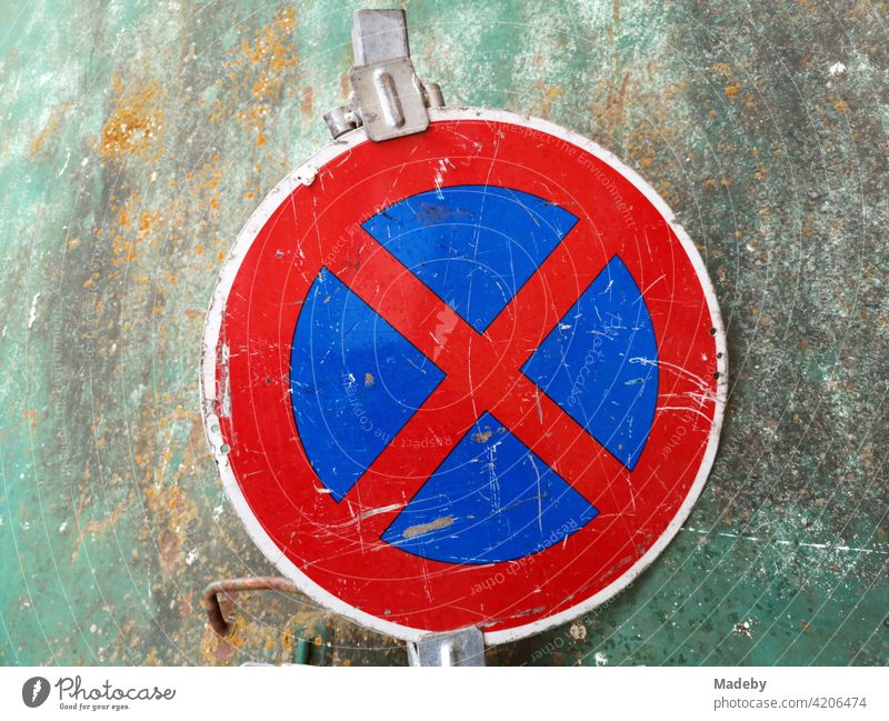 Strict no stopping in front of a yellowed green glass container in Offenbach on the Main in Hesse No standing Transport Road sign Sign symbol symbolism Red Blue