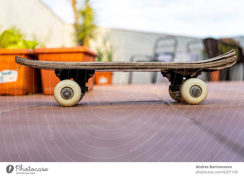 View of an old skateboard on the terrace of the house. Selective focus skateboarding extreme concrete surfing wheel view leisure side paint high enjoyment