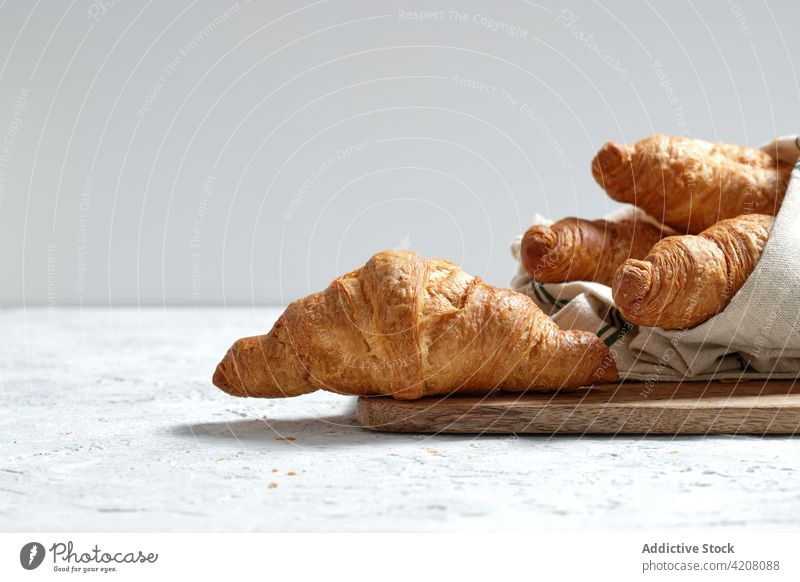 Sweet croissants on wooden board on table breakfast baked meal food bakery morning dessert treat napkin pastry tradition delicious tasty yummy gastronomy fresh
