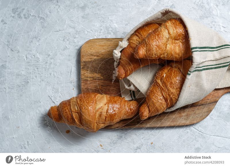 Sweet croissants on wooden board on table breakfast baked meal food bakery morning dessert treat napkin pastry tradition delicious tasty yummy gastronomy fresh