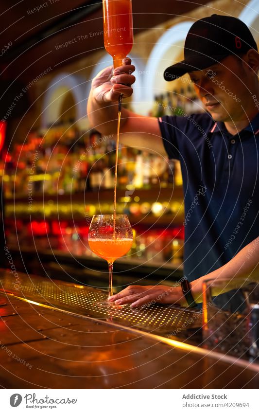 Detail of bartender's hand working in the bar with his shaker and pouring a  cocktail in the glass - a Royalty Free Stock Photo from Photocase