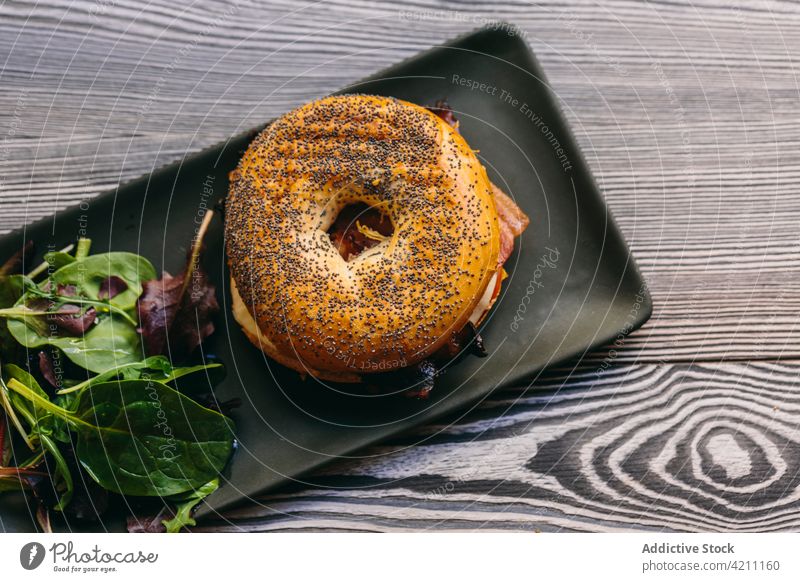 Tasty bagel sandwich on table in cafe meat serve tasty chicken appetizing food meal delicious salad plate rucola arugula cheese culinary nutrition portion