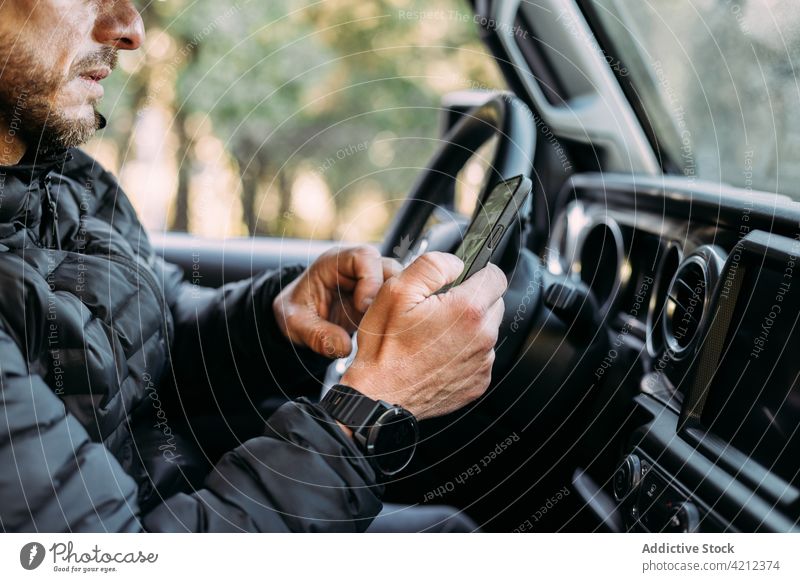 Unrecognizable man using his mobile inside the car smartphone hand interior road driver person cellphone communication technology call transport transportation