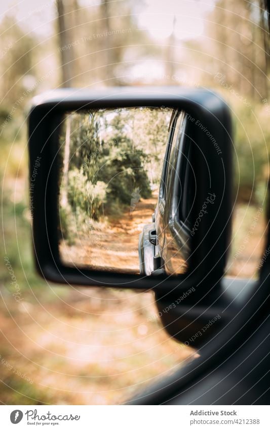 Rear view of an off-road car driving through a mountain road rear mirror drive travel motion reflection transportation holiday vacation outdoor off road