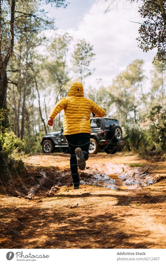 Back view of adventurer running next to his off-road car man travel freedom journey nature outdoor enjoy holiday lifestyle traveler vacation relax vehicle male