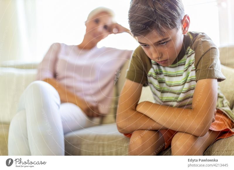 Angry boy and frustrated mother sitting on sofa upset argue angry problem teenager conflict arguing serious attitude child son resentful stress frustration