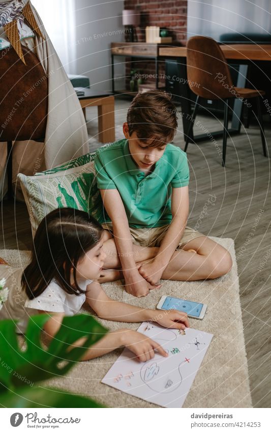 Children playing in a tent at home boy girl living room camp pointing map find treasure mobile compass fun at home home vacation family child leisure children