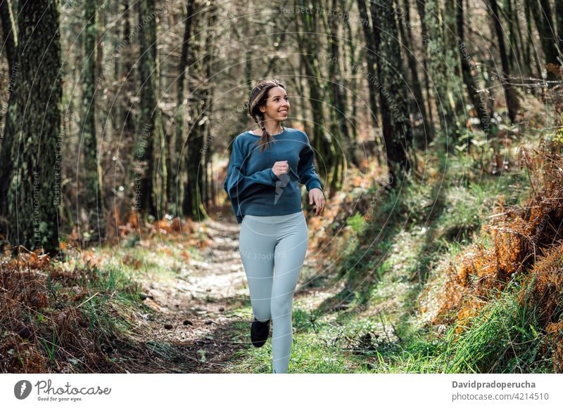 Sporty woman running in forest sporty active training fitness activewear workout woods activity runner sportswoman jog healthy path trail wellness jogger