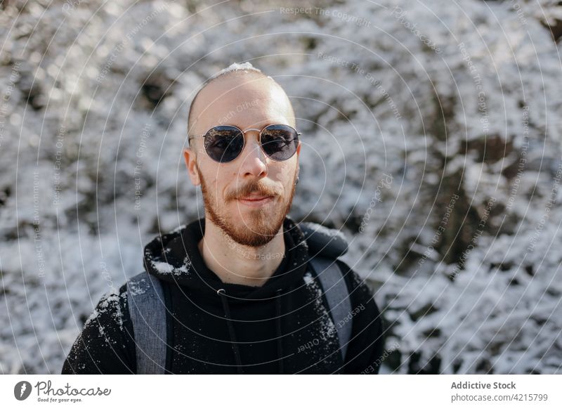 Hiker in sunglasses against winter trees during trip hipster hiker friendly journey natural man portrait snow environment wintertime cold weather traveler