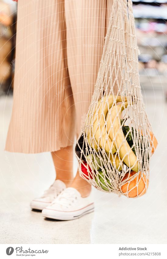 Anonymous woman with mesh bag full of ripe groceries grocery cotton food eco friendly zero waste fruit vegetable female healthy food shopper natural fresh