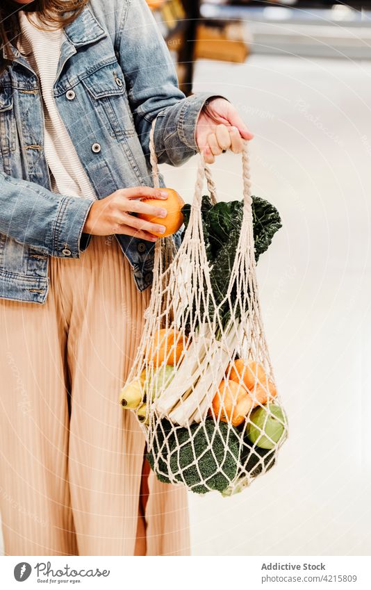 Anonymous woman with mesh bag full of ripe groceries grocery cotton food eco friendly zero waste fruit vegetable female healthy food shopper natural fresh