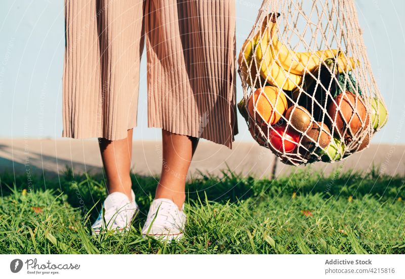 Crop woman with fresh groceries in mesh bag grocery eco friendly cotton zero waste fruit vegetable healthy food female ripe shopper natural organic pile heap