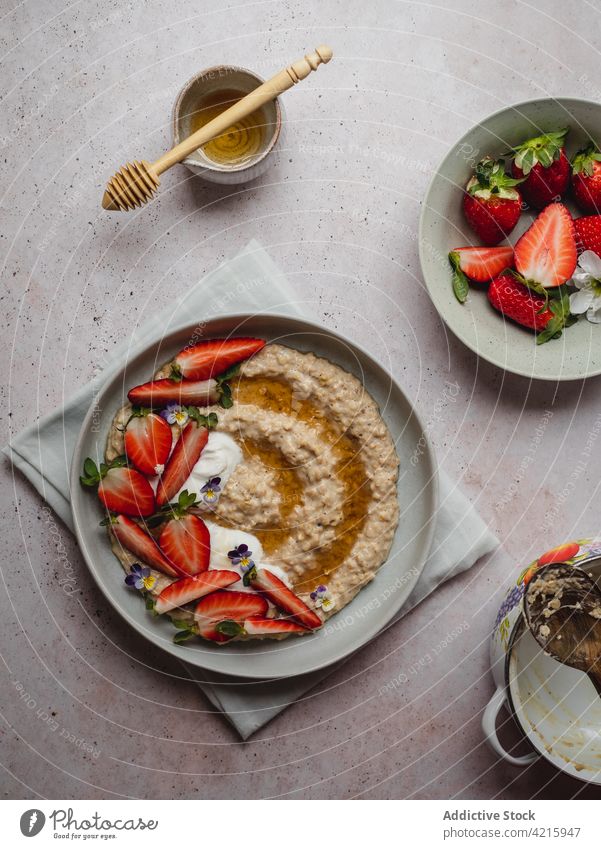 Closeup of a delicious plate of strawberry porridge food oatmeal breakfast healthy fruit cereal bowl granola snack white sweet vegetarian table flakes nutrition