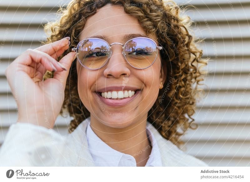 Content ethnic woman in stylish sunglasses in city style smile cheerful afro hairstyle trendy curly hair female black african american happy fashion optimist