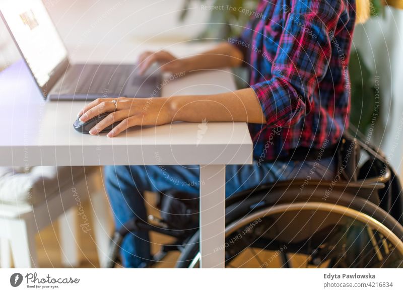 Woman in wheelchair using laptop in office domestic life disability disabled confidence woman independent indoors home house people young adult casual female