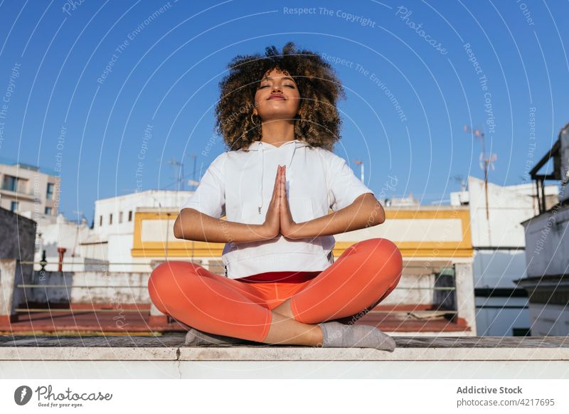 Black woman sitting in Lotus Pose and meditating during yoga lesson meditate online laptop lotus pose padmasana practice tranquil female ethnic black